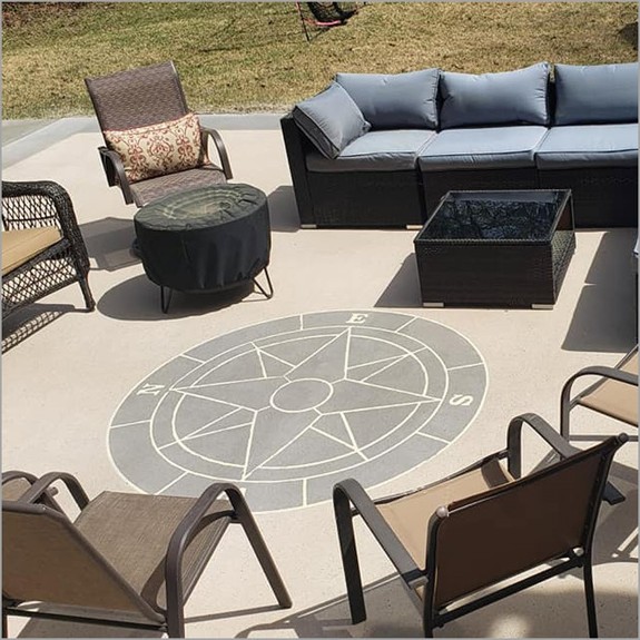 a compass stencil incorporated on concrete overlay on a patio done in light brown concrete